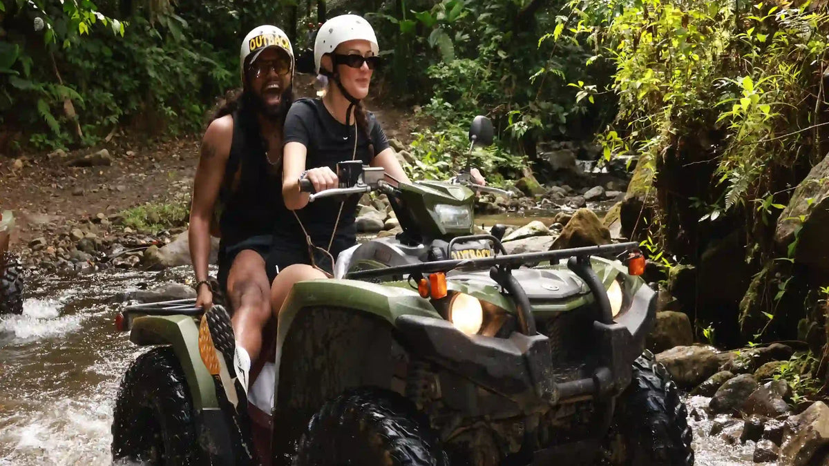 ATV riders crossing a rainforest stream near La Fortuna