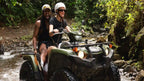 ATV riders crossing a rainforest stream near La Fortuna