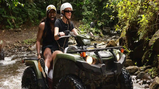 ATV riders crossing a rainforest stream near La Fortuna