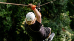 Zipline participant crossing the canopy at Vista Los Sueños, Herradura