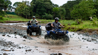 ATV riders crossing a shallow river at Vista Los Sueños