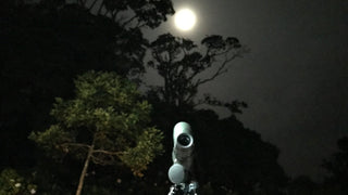 Spotting scope beneath a moonlit sky and trees at Refugio Monteverde
